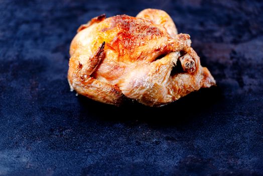 Whole oven roasted chicken on stone surface