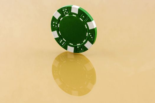 On the reflecting surface is green casino chip