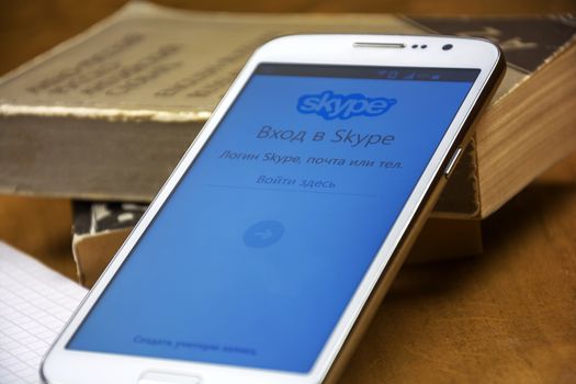 On the smartphone's screen, the start page of Skype is open