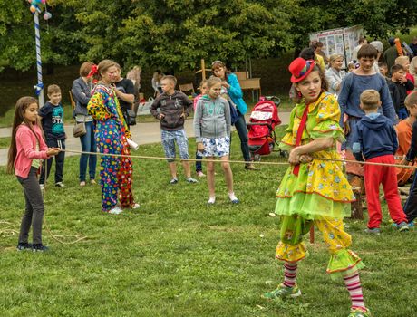 Children and dressed in clown costume a woman playing in the fresh air