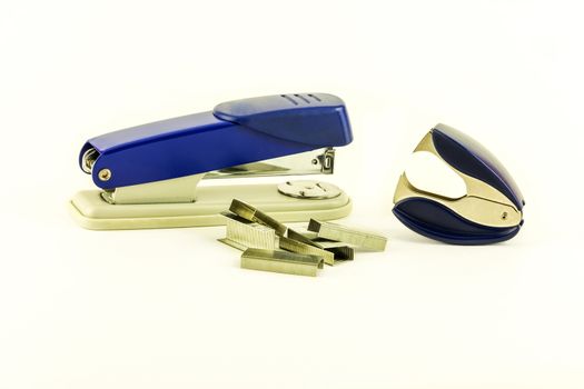 On a white background lie a stapler, staples for stapler and anti-stapler