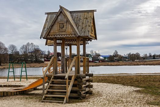 On the shore of the pond there is a wooden gazebo with a staircase