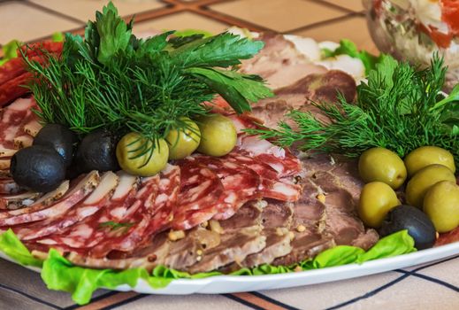 Meat cut with olives, olives, dill and parsley