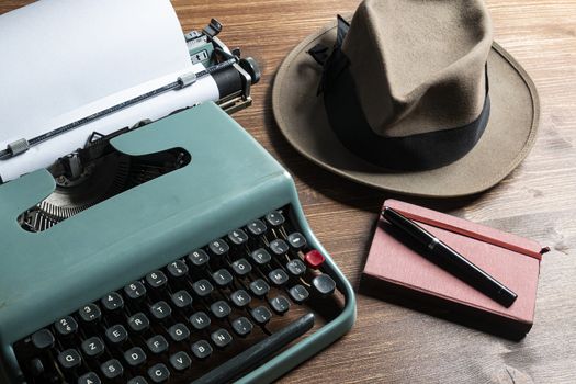 An old typewriter, a notebook and a reporter's hat