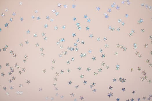 New Year's light background. Silvery stars on a light pink background.