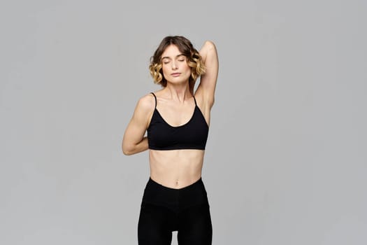 woman in short t-shirt goes in for sports on a gray background exercise exercise copy space. High quality photo