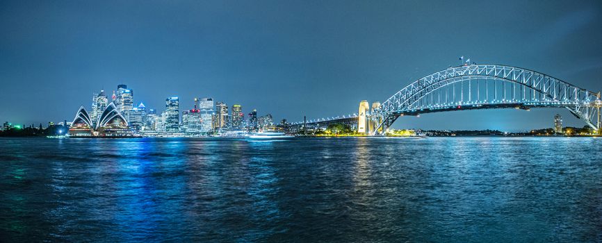 Panoramic photo of Sydney skyline with Harbour Bridge in the evening after sunset. New South Wales, Australia