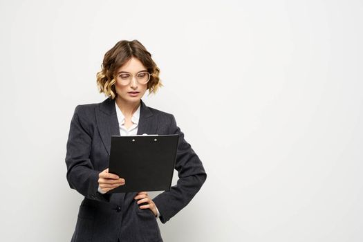 business woman in a suit with documents in hands light background curly hair hairstyle. High quality photo