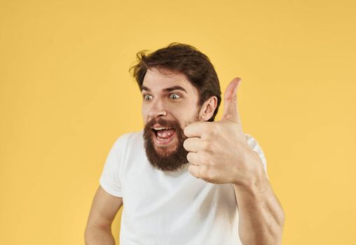 Man shows positive hand gesture emotions fun yellow background. High quality photo