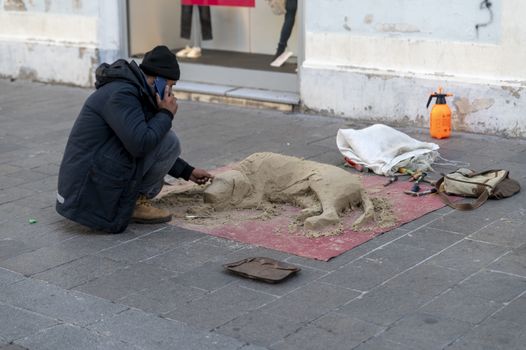 terni,italy october 21 2020:street artist making composition of a dog with sand