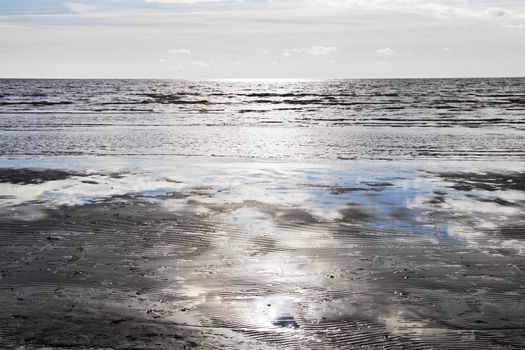 Seascape of sea water and beach, sand and clouds , horizon in Estonia.