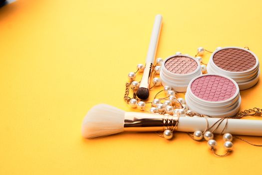 Eyeshadows on a yellow background professional cosmetics makeup brushes soft sponge fashion glasses. High quality photo