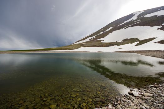 Alpine mountain lake landscape and view, snow and clouds in Javakheti, Georgia