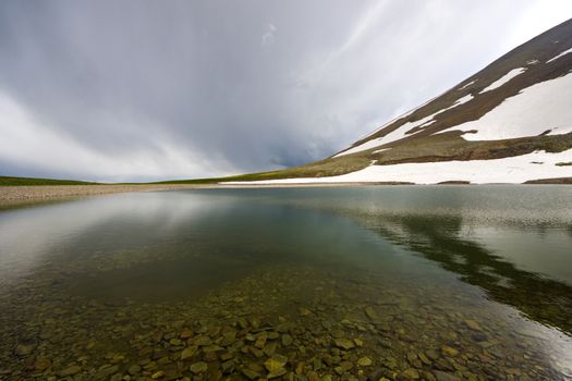 Alpine mountain lake landscape and view, snow and clouds in Javakheti, Georgia