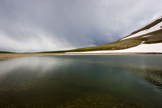 Alpine mountain lake landscape and view, snow and clouds in Javakheti, Georgia