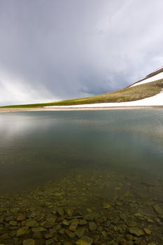 Alpine mountain lake landscape and view, snow and clouds in Javakheti, Georgia