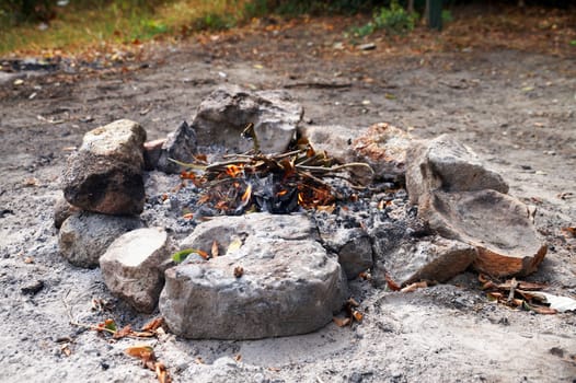 fading bonfire, fenced with stones close-up