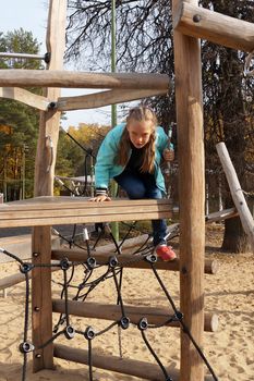 child girl climbing rope playground in the park.
