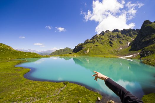 Alpine mountain lake landscape and view, blue beautiful and amazing lake panorama, wide angle lens landscape and mountain reflections in Okhrotskhali in Svaneti, Georgia.