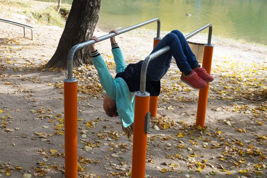 child girl is engaged on the sportground in the park.