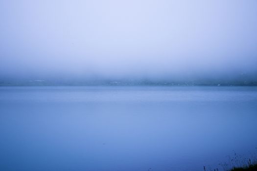 Mountain lake and fog, misty lake, amazing landscape and view of alpine lake Okhrotskhali in the Svaneti, Georgia