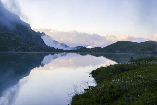 Mountain lake and fog, misty lake, amazing landscape and view of alpine lake Okhrotskhali in the Svaneti, Georgia