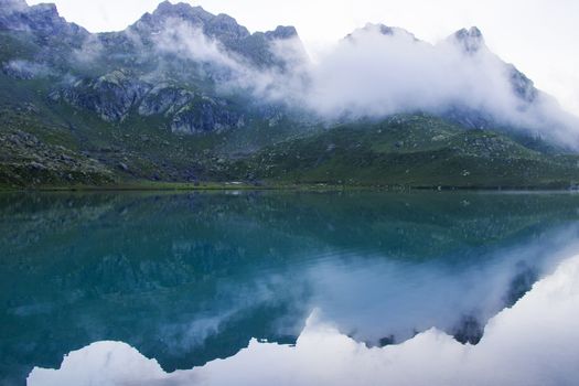 Mountain lake and fog, misty lake, amazing landscape and view of alpine lake Okhrotskhali in the Svaneti, Georgia