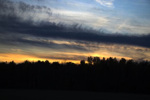 Sunset colored sky, blue, yellow, orange and red, mixed colors,shadows and lights, in Europe