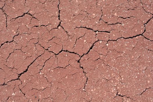 Detail of a concrete cracked red floor