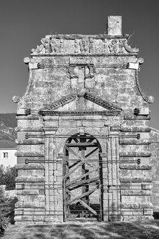 Gate and bell tower of the historic orthodox church of Evangelistria on the island of Kefalonia in Greece, monochrome