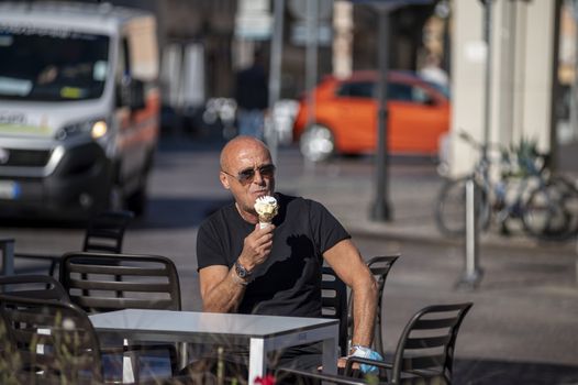 terni,italy october 21 2020:sitting man eating an ice cream cone