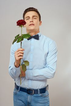 romantic man with red rose and light shirt pants suit. High quality photo