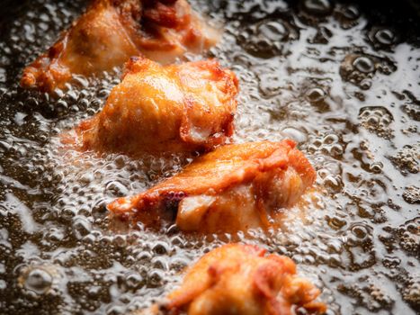 Chicken drumsticks fried in boiling oil. Thai street food.