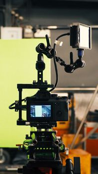 Behind video camera and green screen for movie or film production and equipment in the big studio.