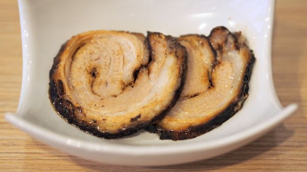 Chashu pork slide 2 pieces for top up on the traditional tonkotsu japanese ramen noodle dish.