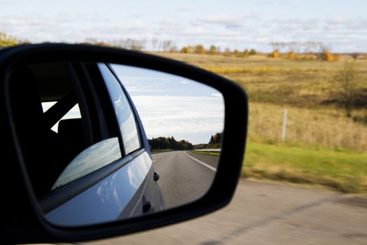 Road in car mirror