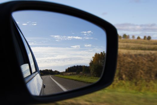 Road in car mirror