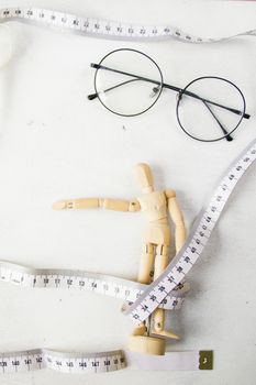 sew set, sew things on the white background. measuring and glass. Studio shoot. Human wooden figure.