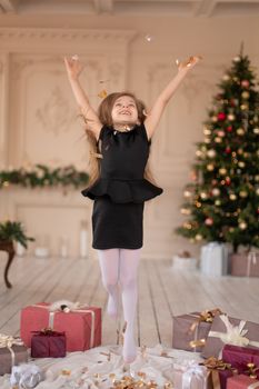 Little girl throws confetti. Christmas magic. Joyful moments of a happy childhood.