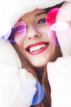 Merry Christmas portrait of smiling young woman wearing fluffy white fur coat, luxury beauty and happy holidays