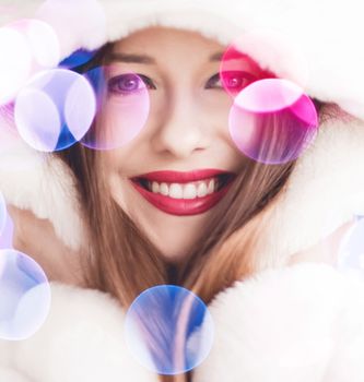 Merry Christmas portrait of smiling young woman wearing fluffy white fur coat, luxury beauty and happy holidays