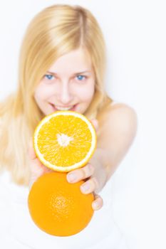 Young blonde holding orange fruit and smiling, healthy eating and organic beauty concept