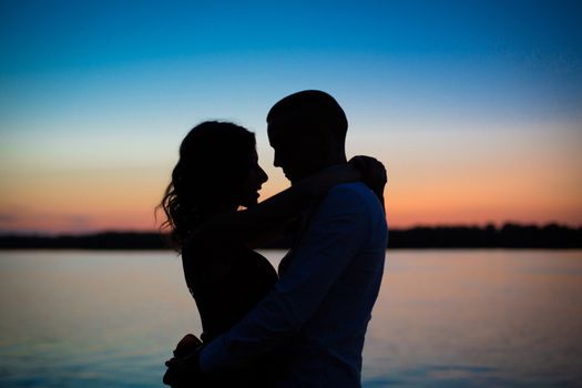 Silhouettes of a couple in love romance at sunset.