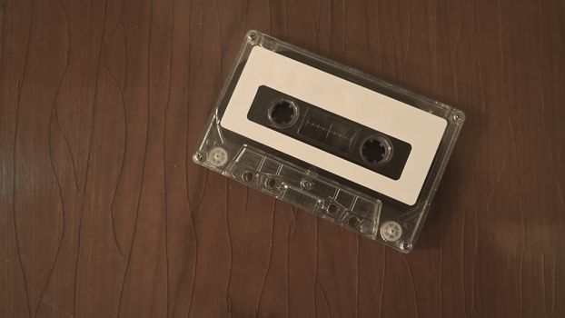 Close-up images of cassette tape on retro wood table. represent nostalgia mood or moment to 80s or 90s that most of audio music or songs recorded in compact and handy device technology.