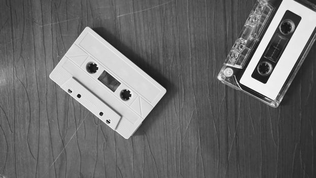 Close-up images of cassette tape on retro wood table. represent nostalgia mood or moment to 80s or 90s that most of audio music or songs recorded in compact and handy device technology.