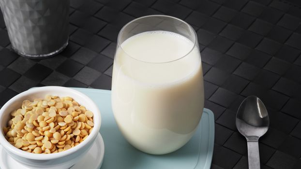 Close-up images of home made healthy drink soy milk with no sugar added in a glass on a green color plastic plate mat and soy beans in small bowl. All of them on black background in a studio shot.