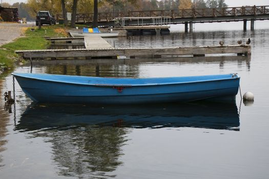 Old wooden boats near the beach of Trakai Gavle lake , Lithuania. Autumn and fall time.