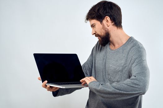 A man in a gray sweater with a laptop hands lifestyle technology communication internet work. High quality photo