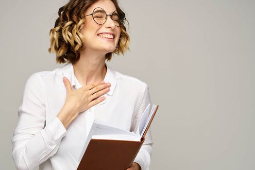 woman with notepad in hands business work beige background glasses hairstyle. High quality photo