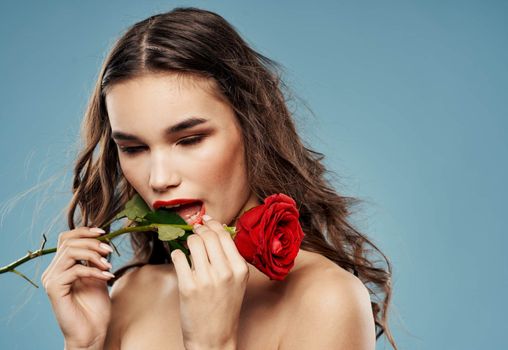 Passionate woman with red rose eye shadow on eyelids blue background cropped view. High quality photo